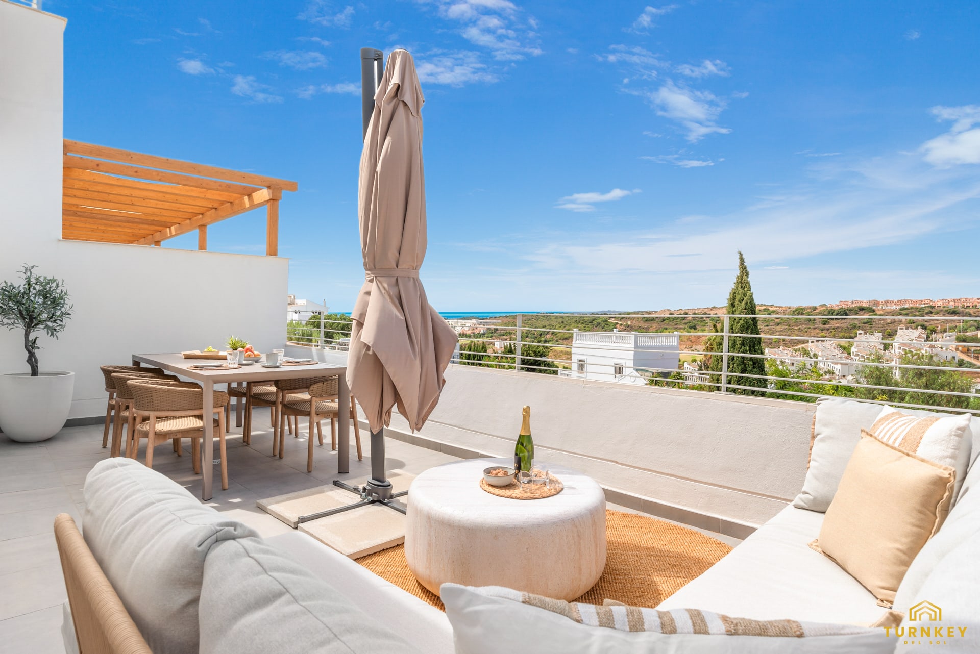 Het terras met eettafel, loungehoek en uitzicht richting zee